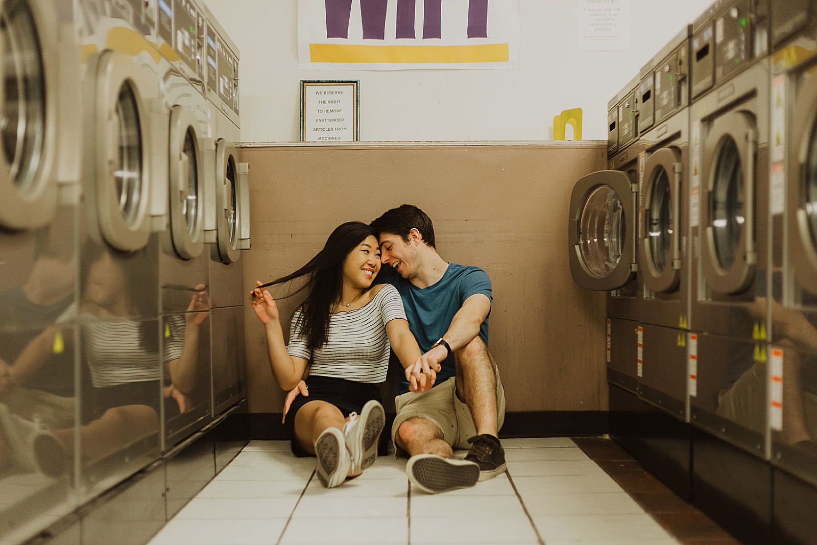 Cute Couple Sitting in Laundromat Engagement Photos taken by Kansas City Engagement Photographer, Caitlyn Cloud Photography
