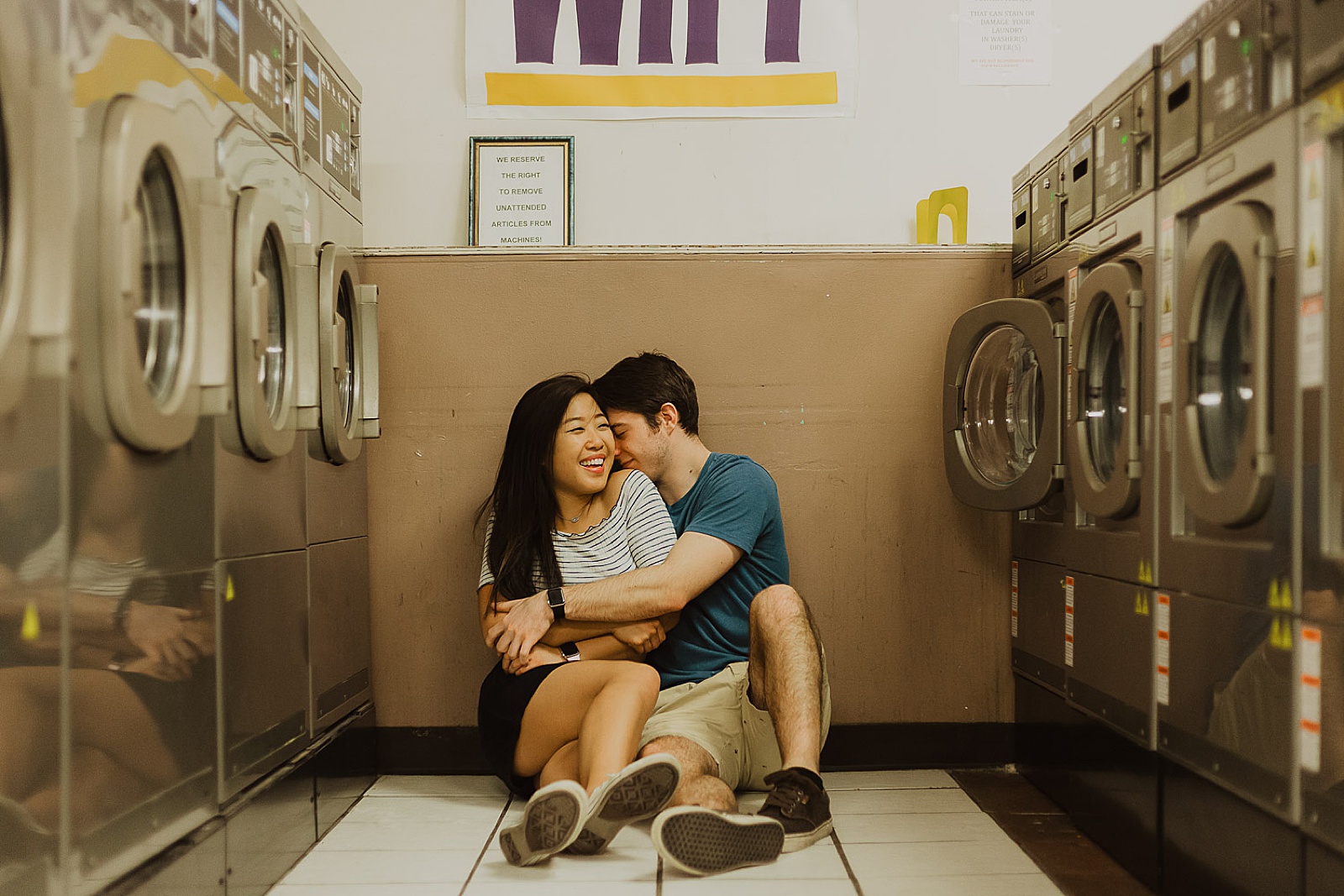 Cute Couple Sitting in Laundromat Engagement Photos taken by Kansas City Engagement Photographer, Caitlyn Cloud Photography
