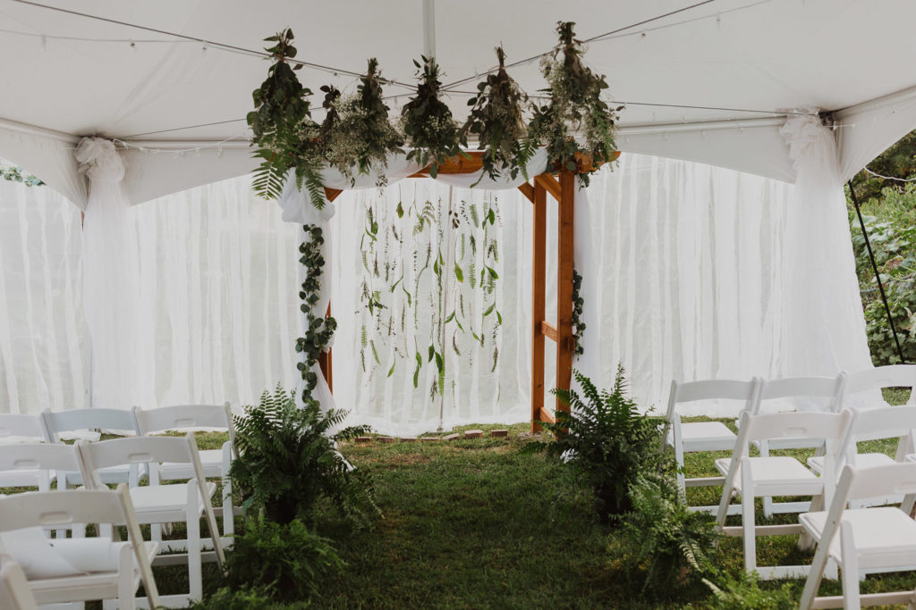 Backyard wedding tent with greenery