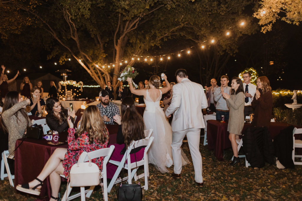 backyard wedding couple entering reception with string lights