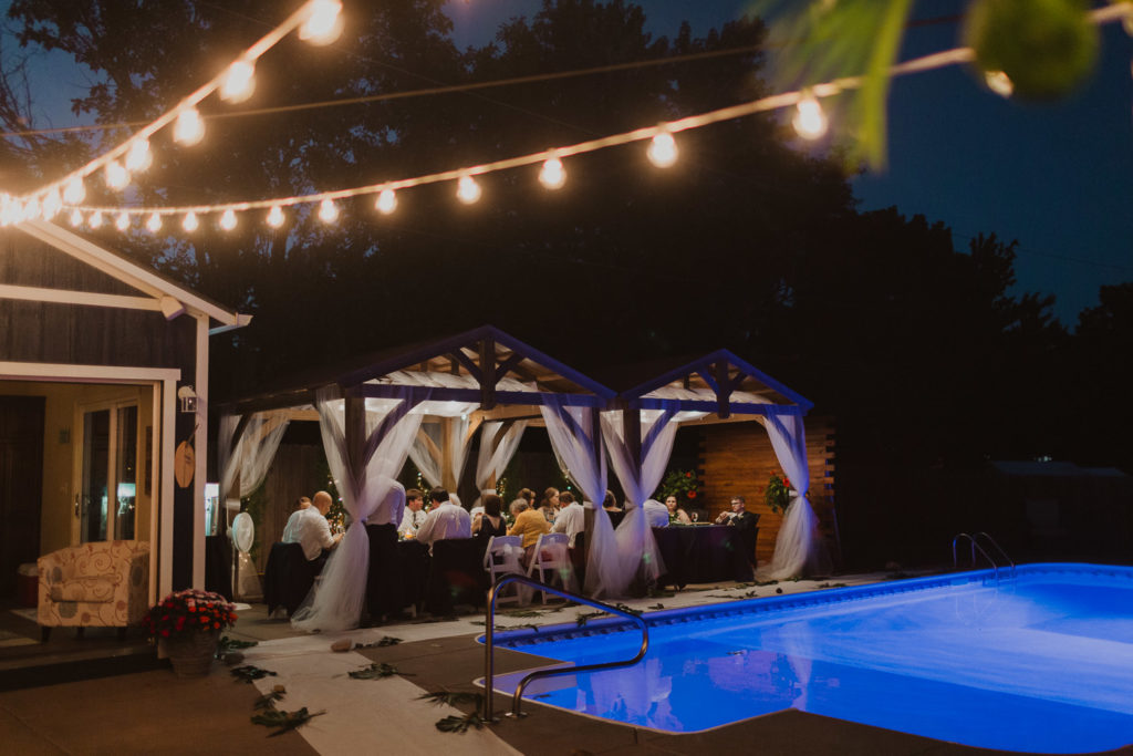 backyard wedding with string lights and banquet table