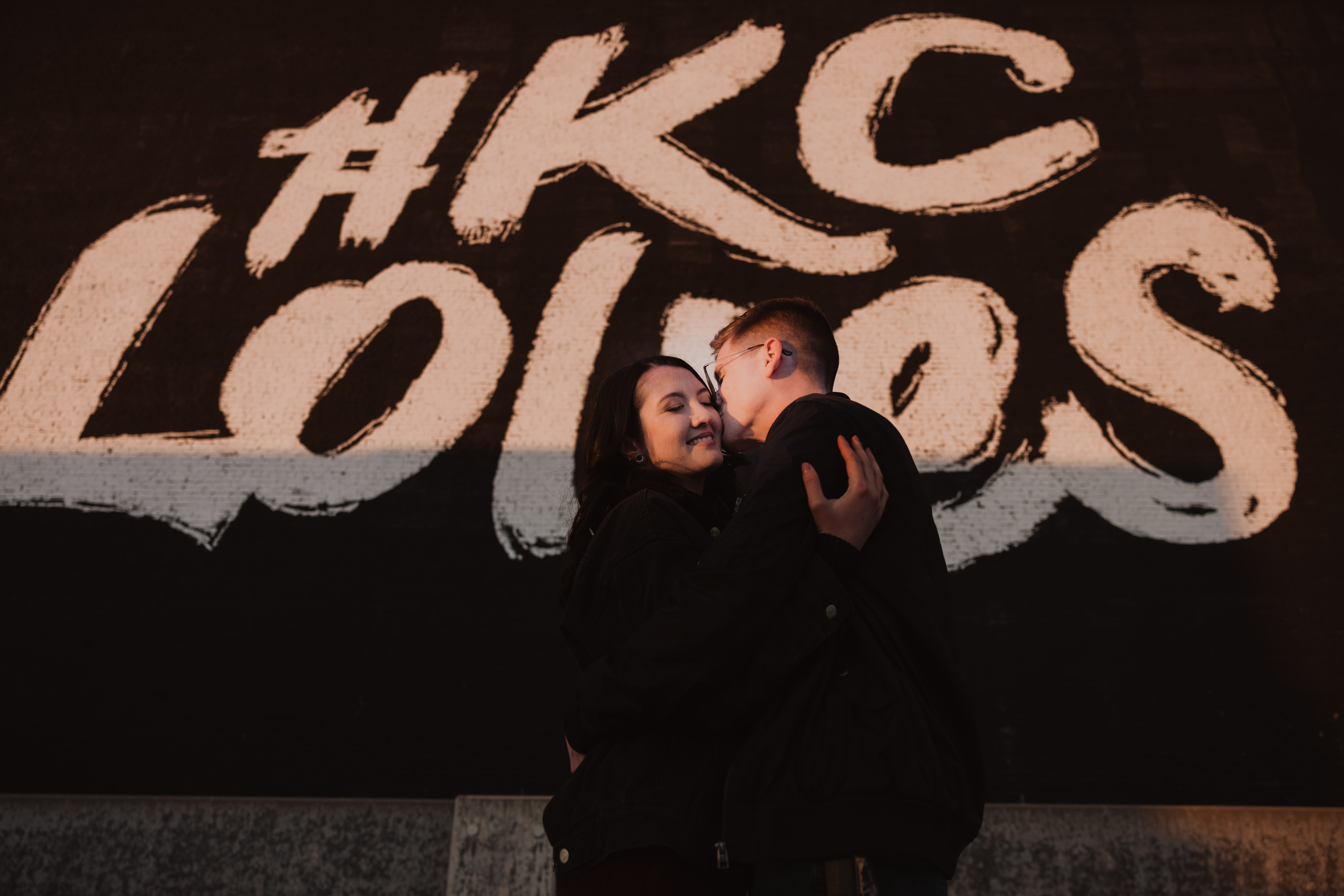 engaged couple in downtown Kansas City Crossroads district standing in front of KC Loves Mural