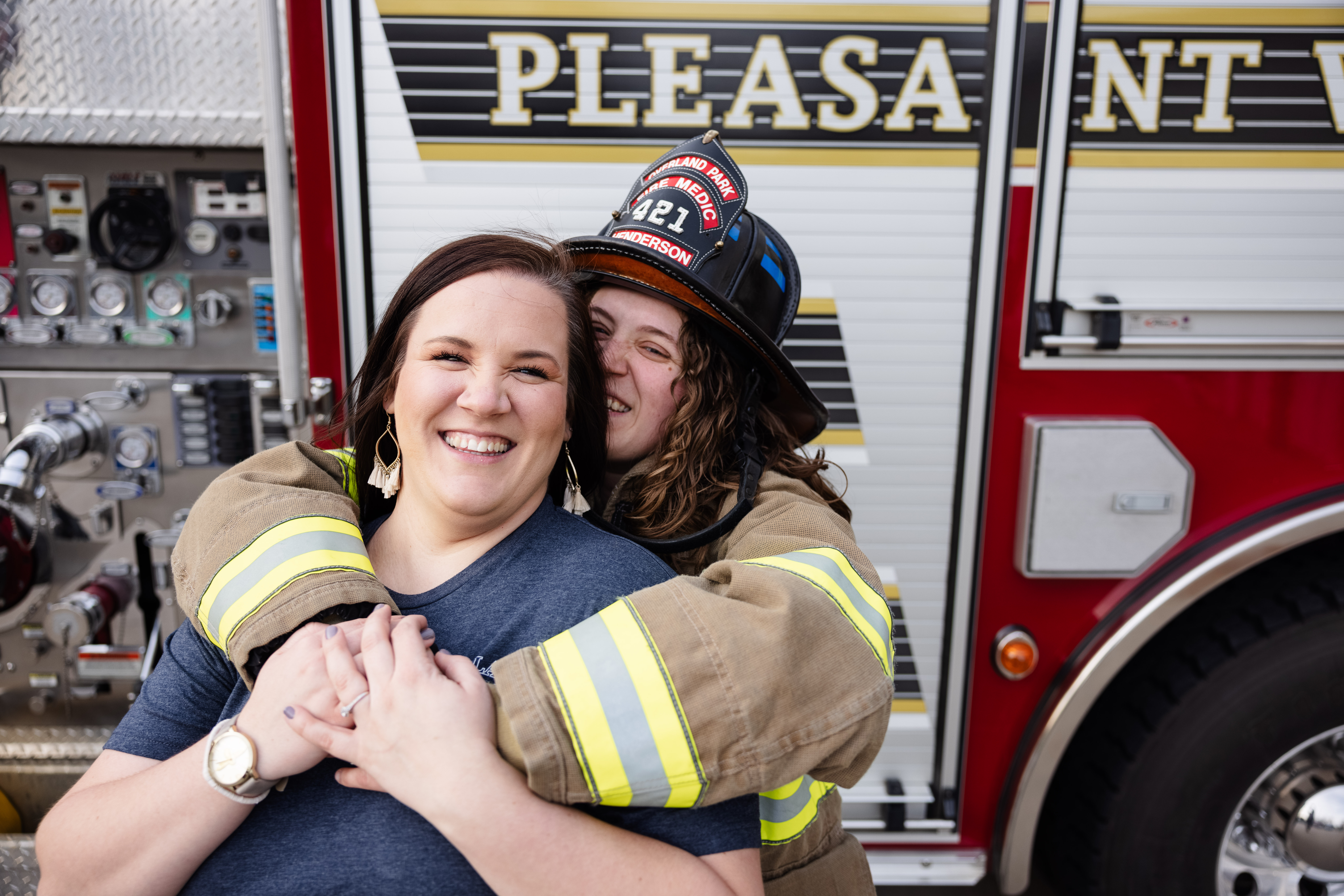 fire fighter engagement session LGBTQ couple hugging in front of fire truck