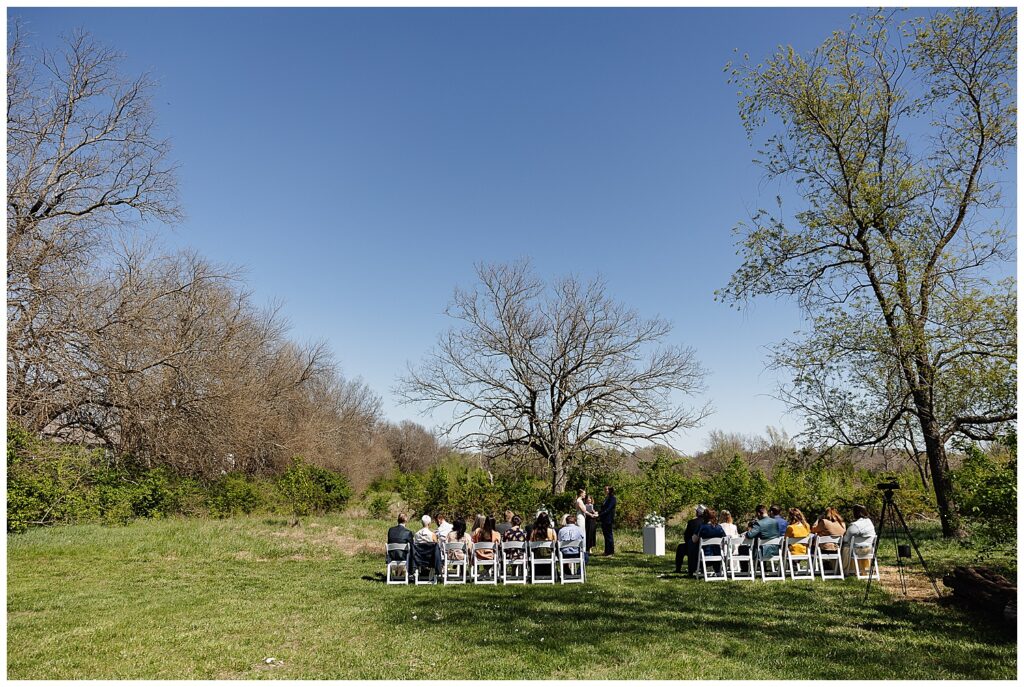 Backyard wedding ceremony in spring. Kansas City area wedding photographer.